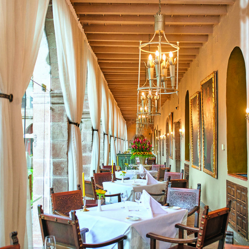Corridor filled with dining tables and chairs at Belmond Hotel Monasterio, Peru