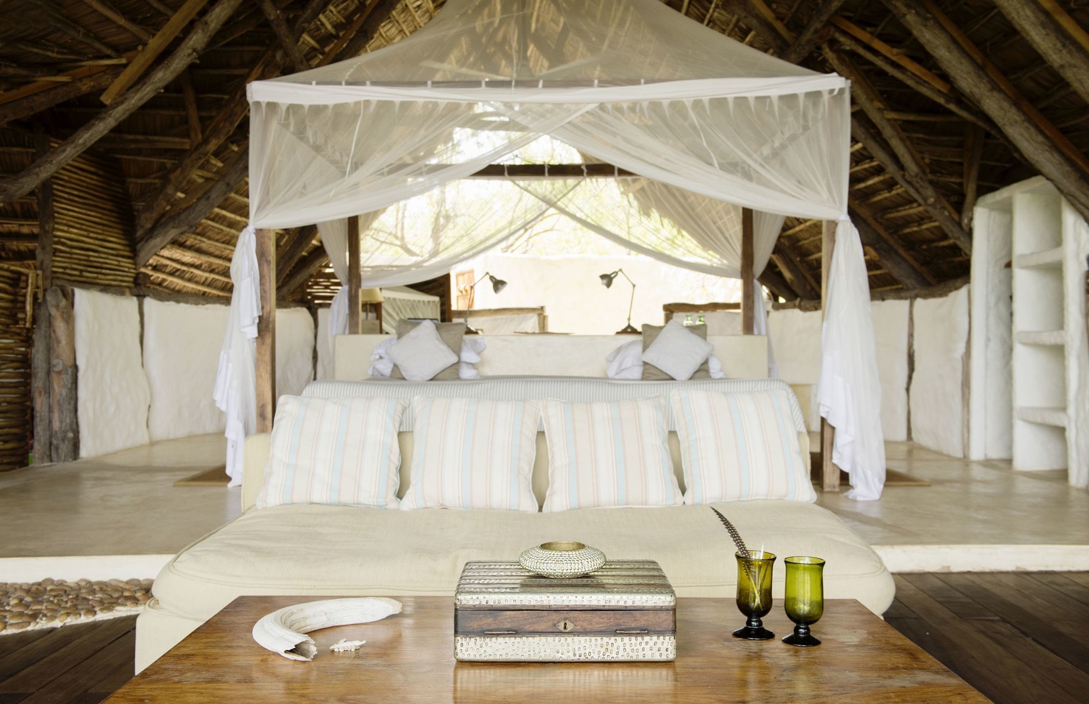 One of Sand Rivers's airy bedrooms featuring a canopy double bed.