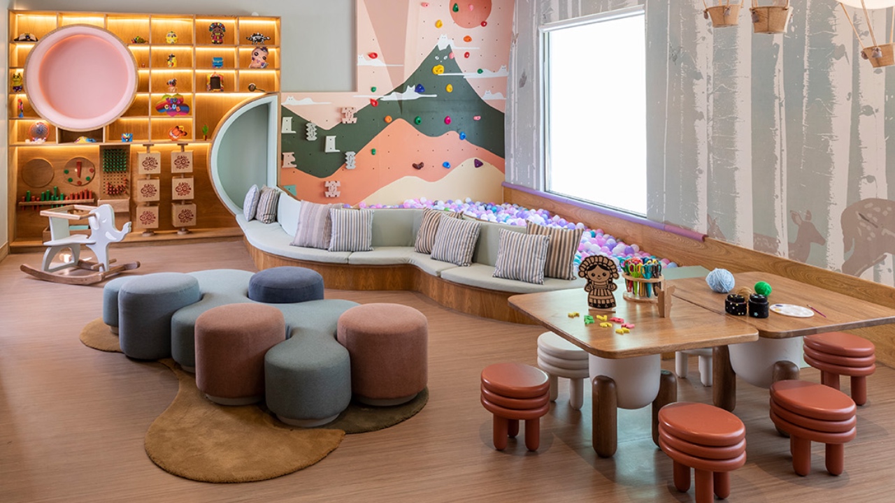 Colorful children's playroom with toys, a ball pit, and kid-sized furniture.