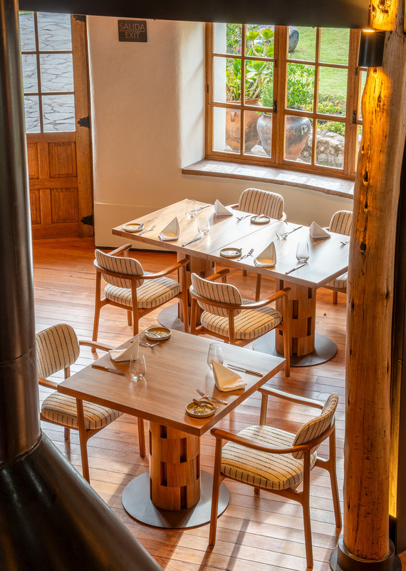 Indoor dining room with wooden tables and chairs. A sign reading SALIDA EXIT hangs above the door.