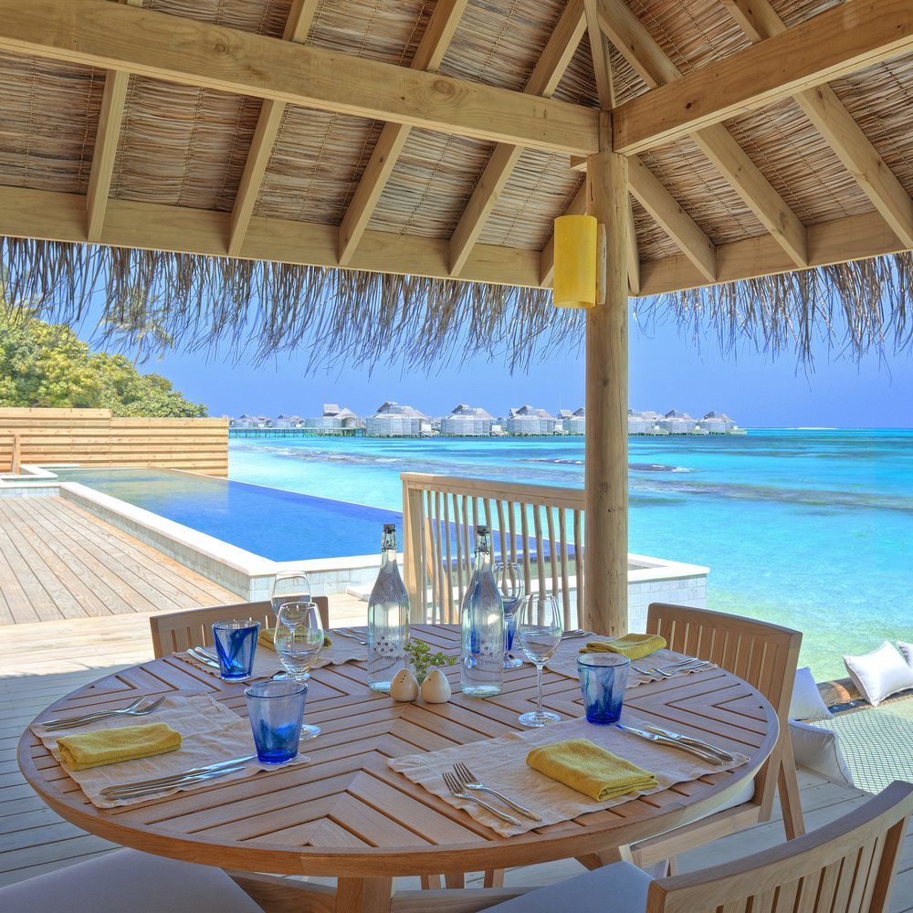 Outdoor dining area with sea view at Six Senses Laamu