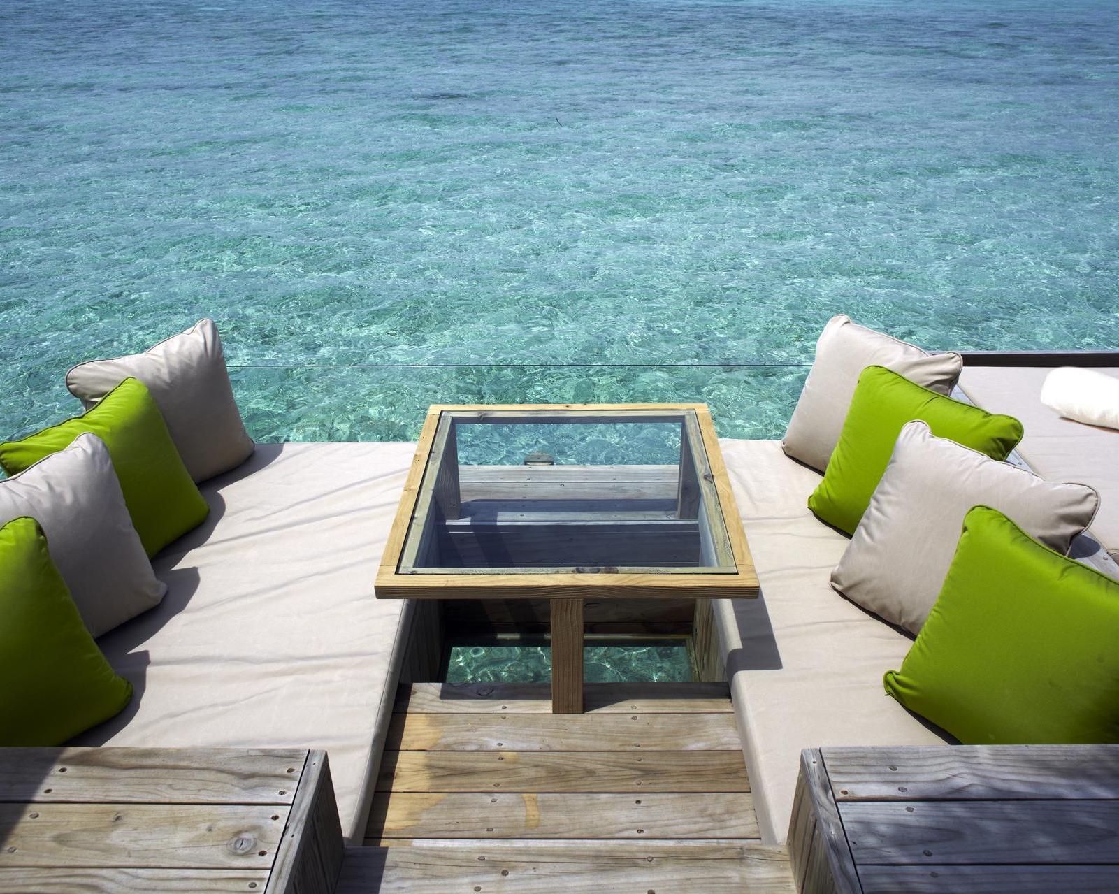 A seating area around an overwater deck at Six Senses Laamu