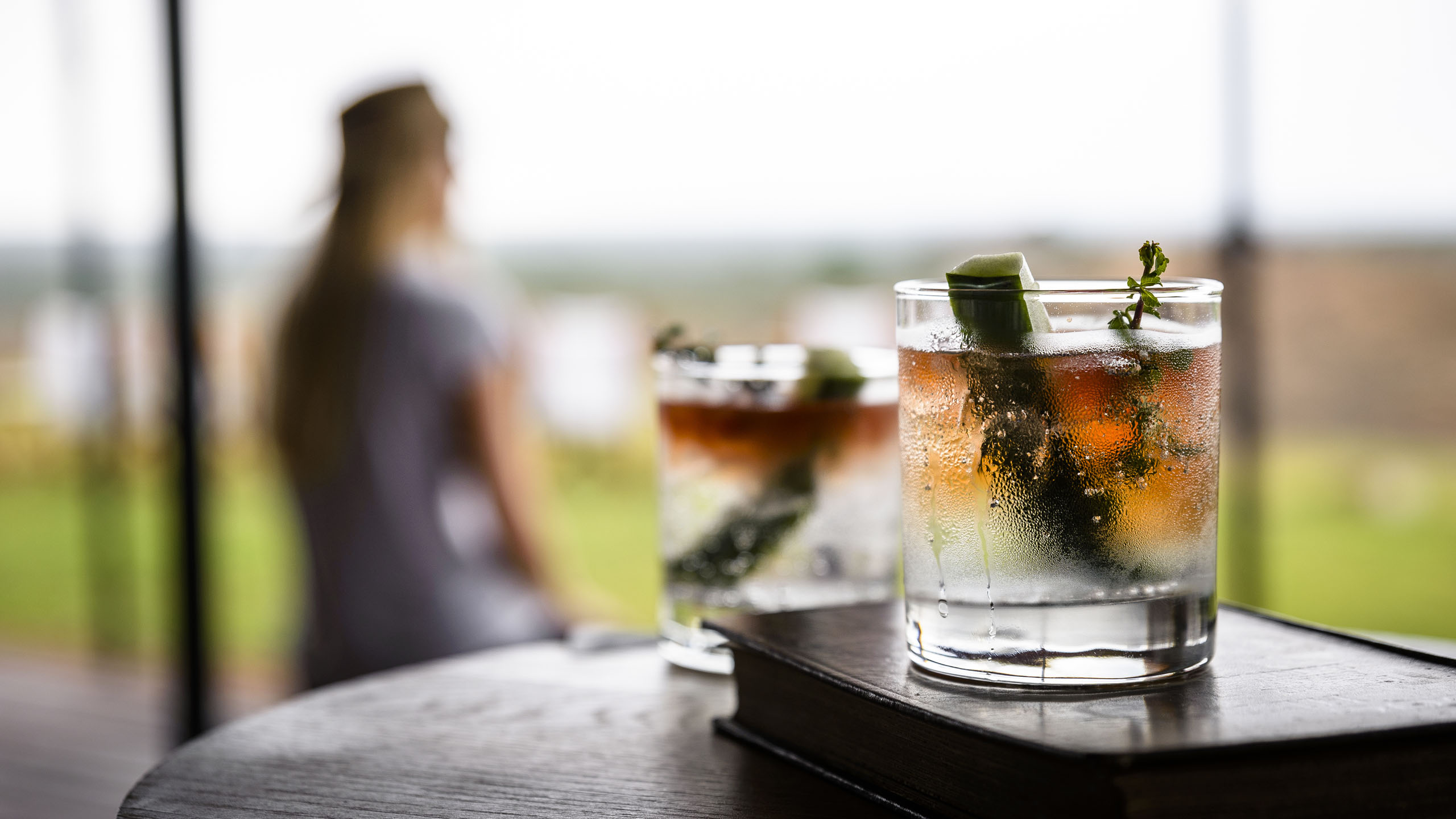 Close up of two glasses with clear and orange liquid in
