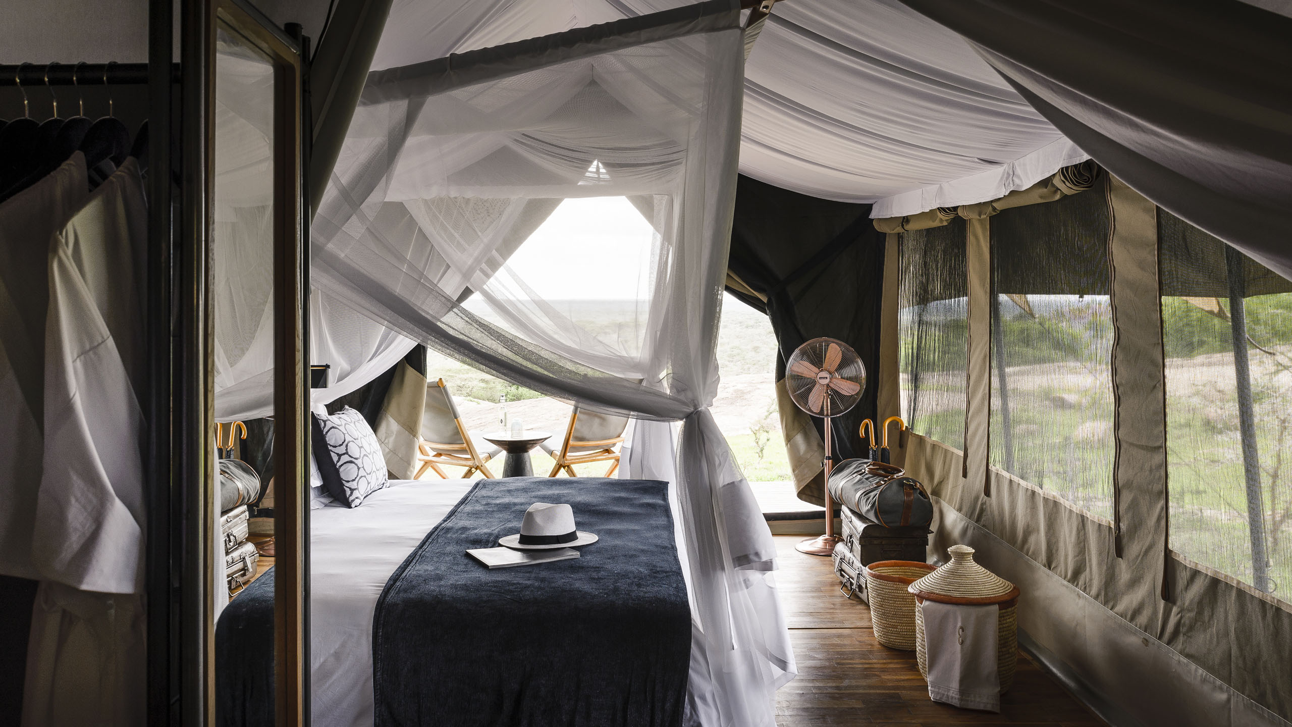 Interior of a camp bedroom with large bed with net drapes