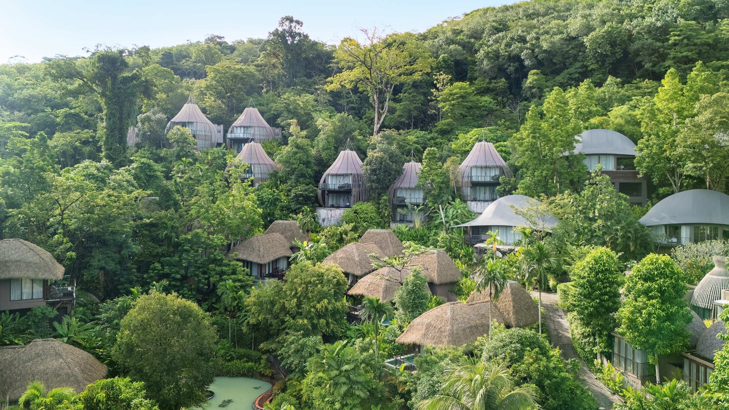 Keemala's villas as seen from afar spread out across a lush forest.