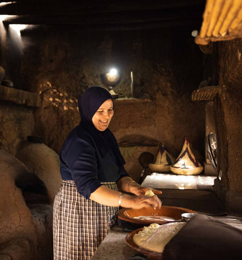 A woman bakes bread in a traditional Berber kitchen in Morocco.