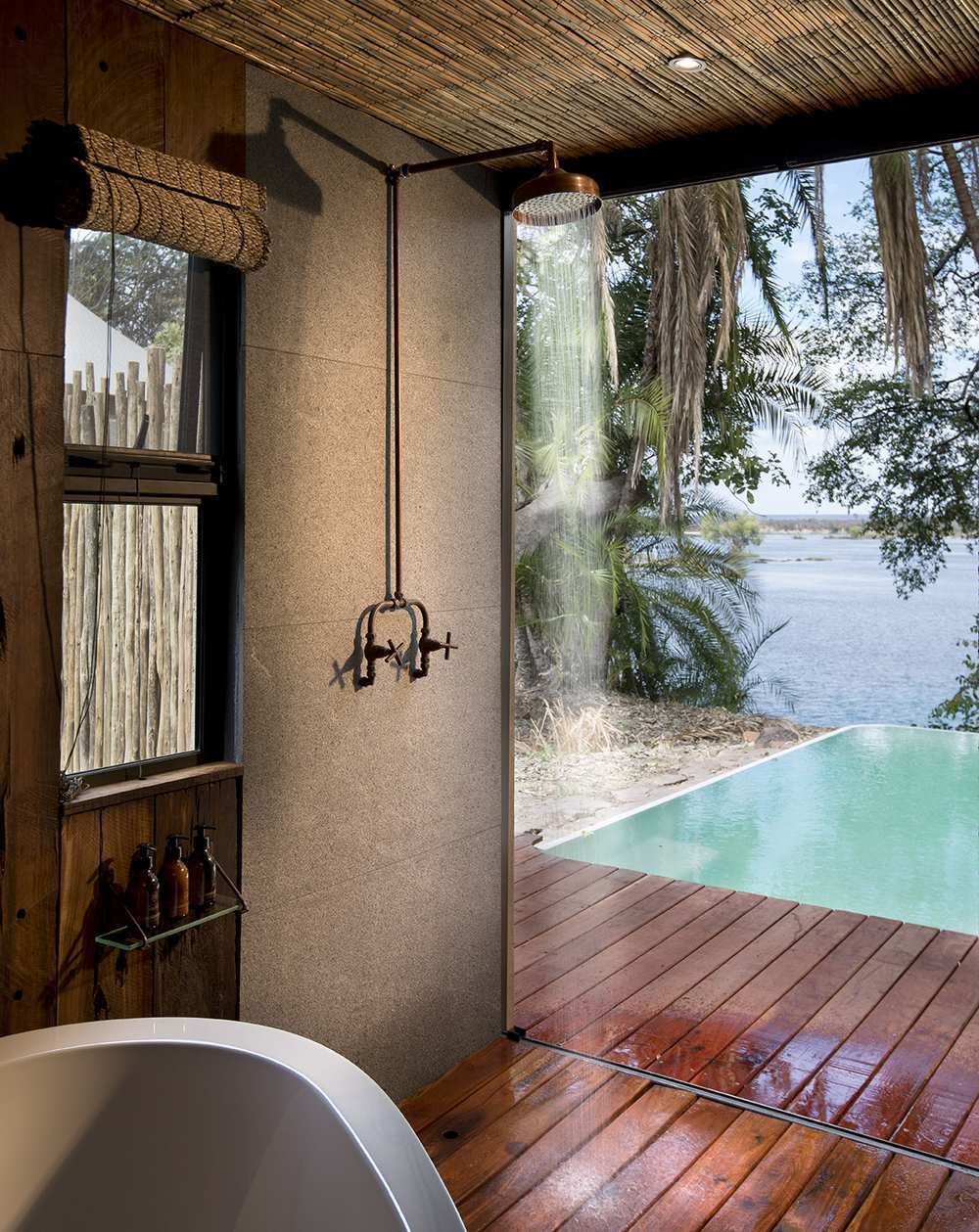 The bathroom of a suite at Thorntree River Lodge, featuring a standalone bath overlooking the private pool area.