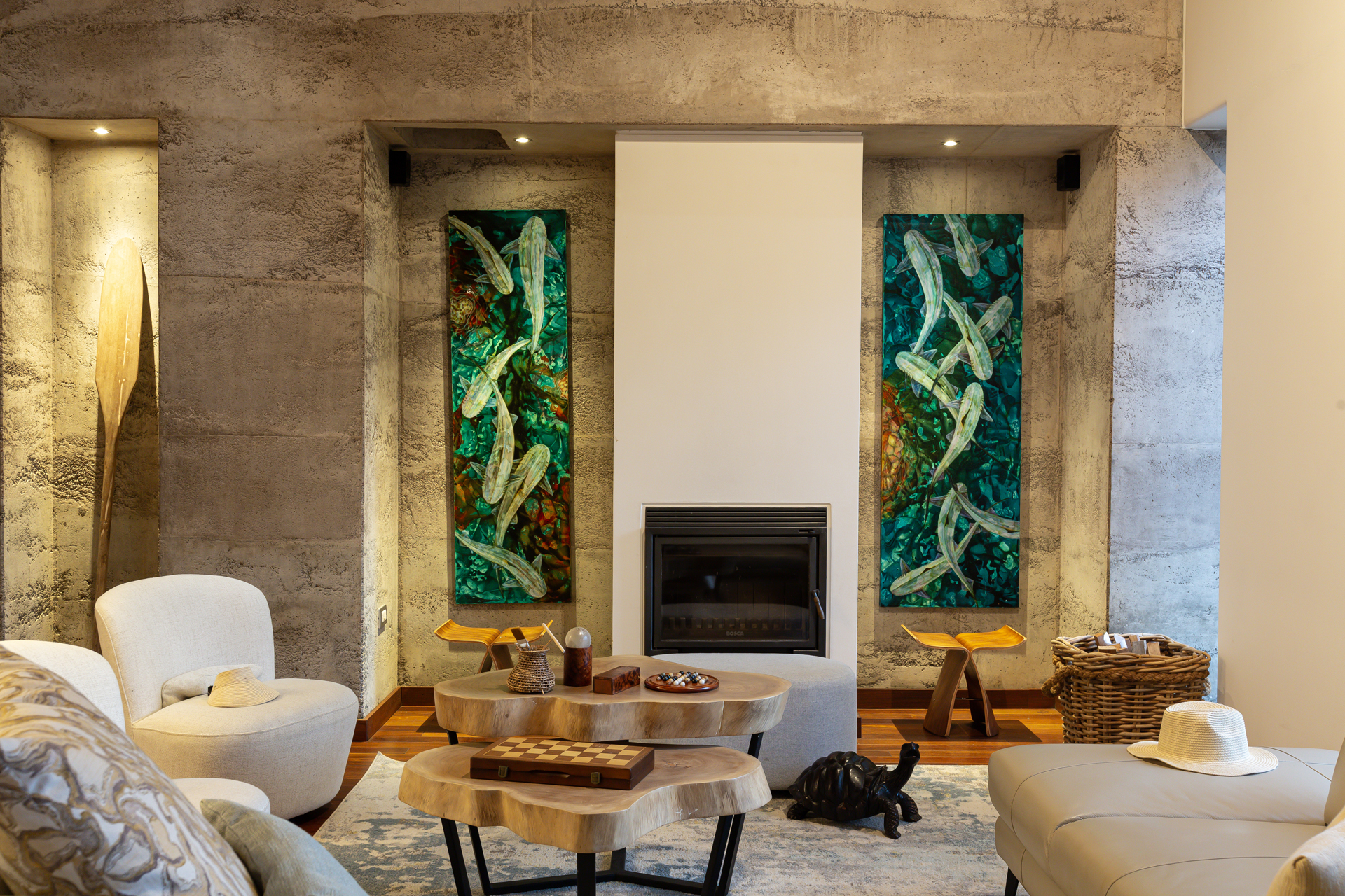 Modern living room with fireplace, abstract art, cozy furniture, and wooden accents.