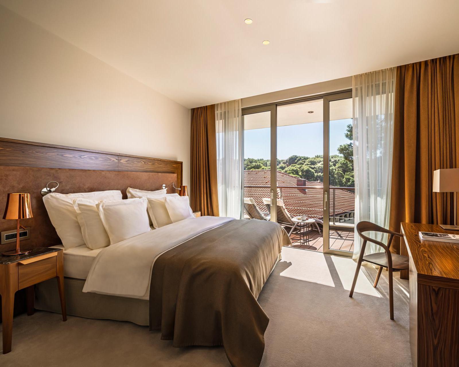 A bedroom with doors leading to a balcony at Boutique Hotel Alhambra in Croatia