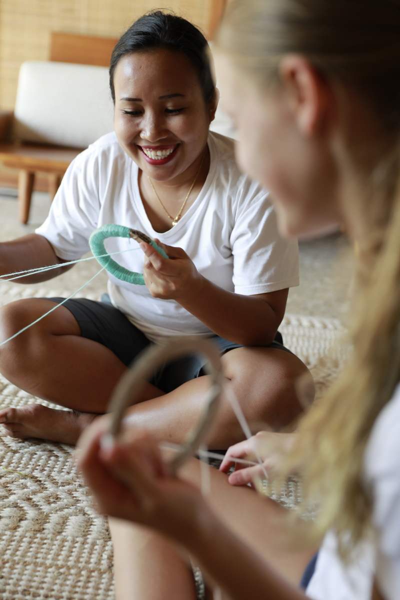 A woman and a child sitting on the floor doing crafts together.