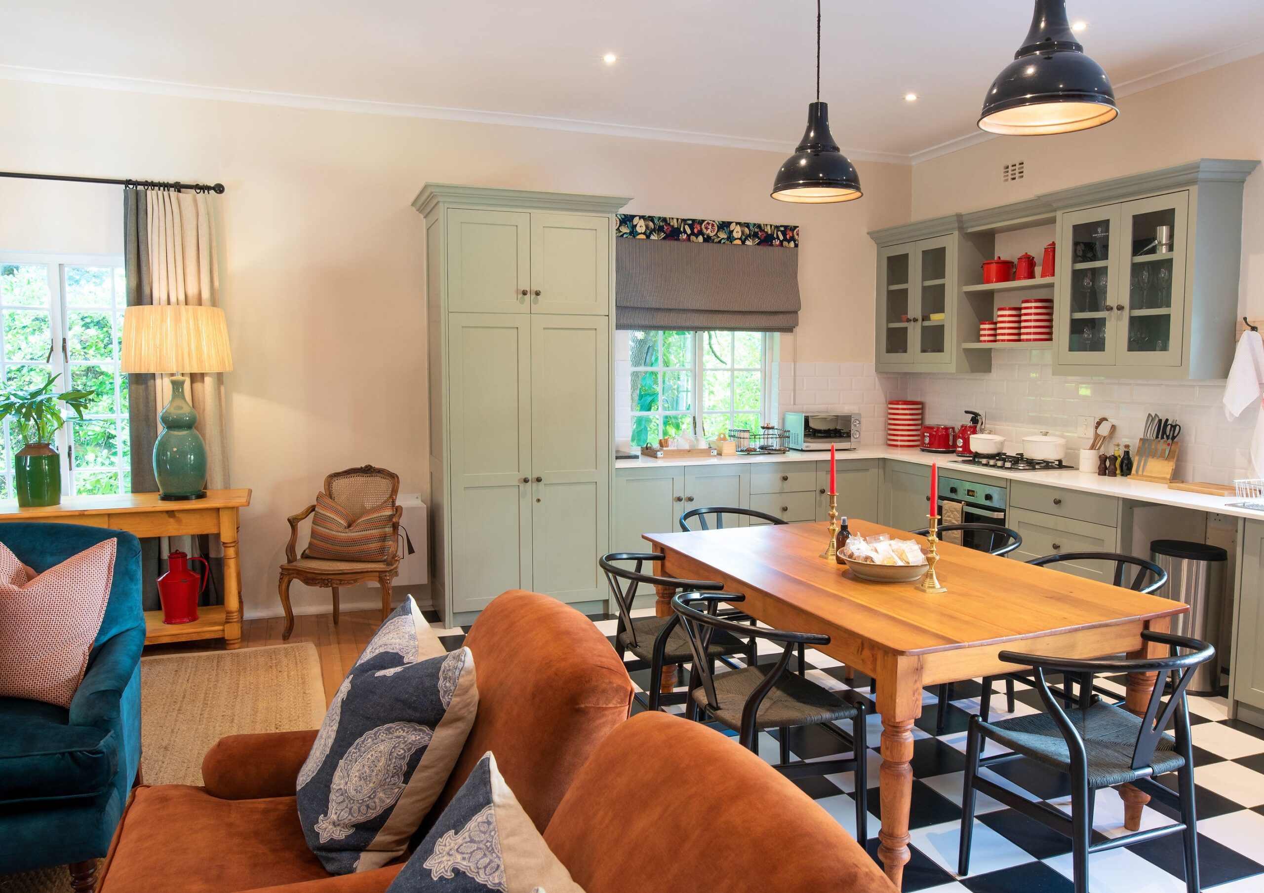 Cozy kitchen interior with dining table, blue cabinets, and checkered floor.