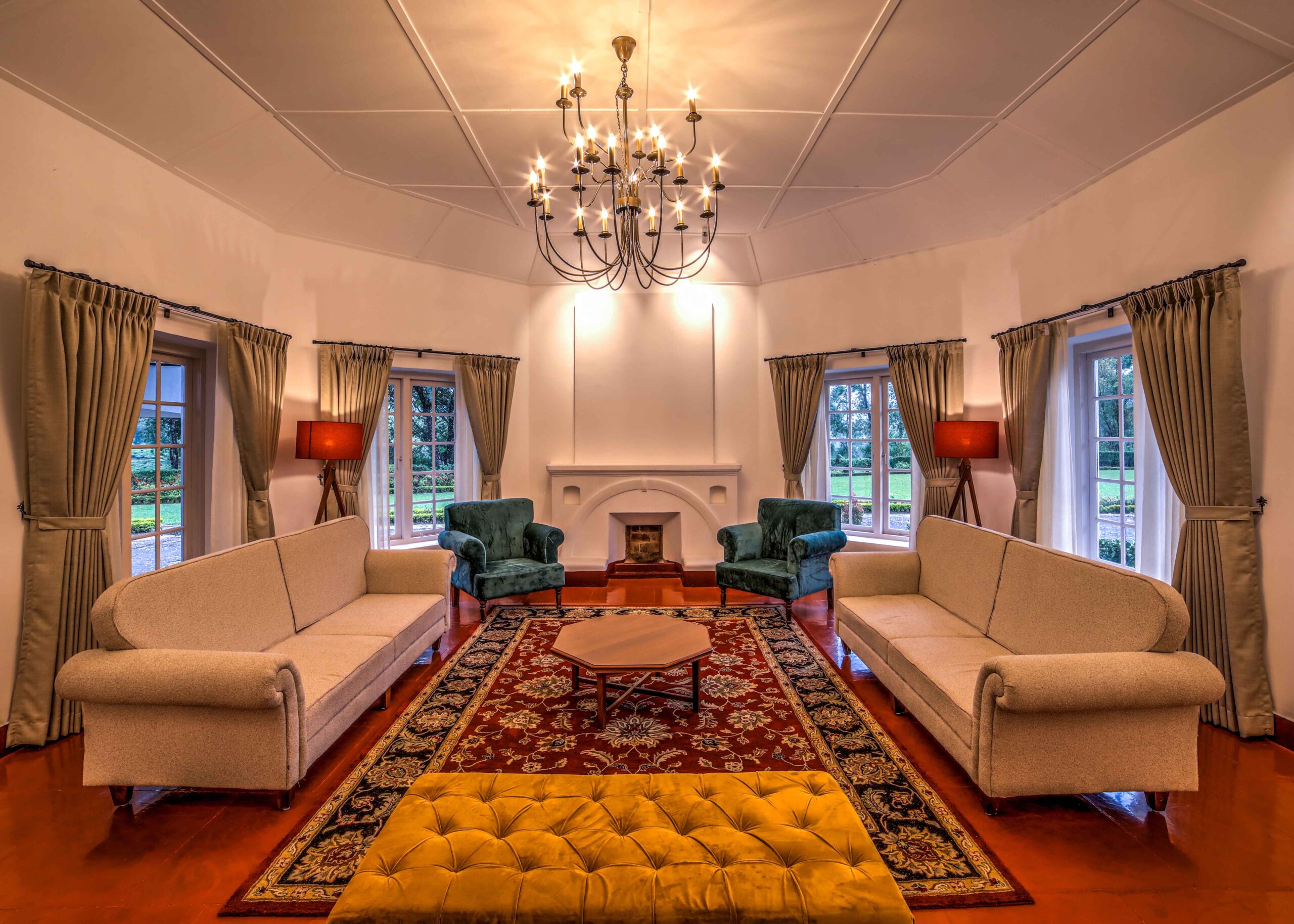Elegant living room with sofas, chandelier, and large windows.
