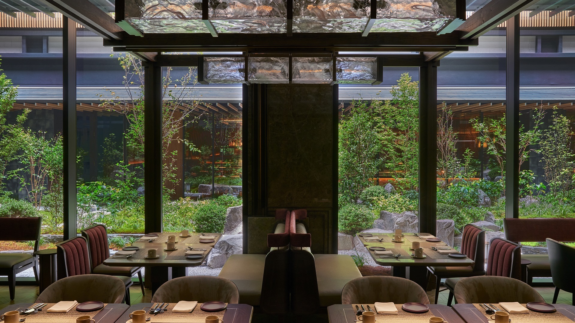 Elegant dining area with large windows overlooking a serene Japanese garden.