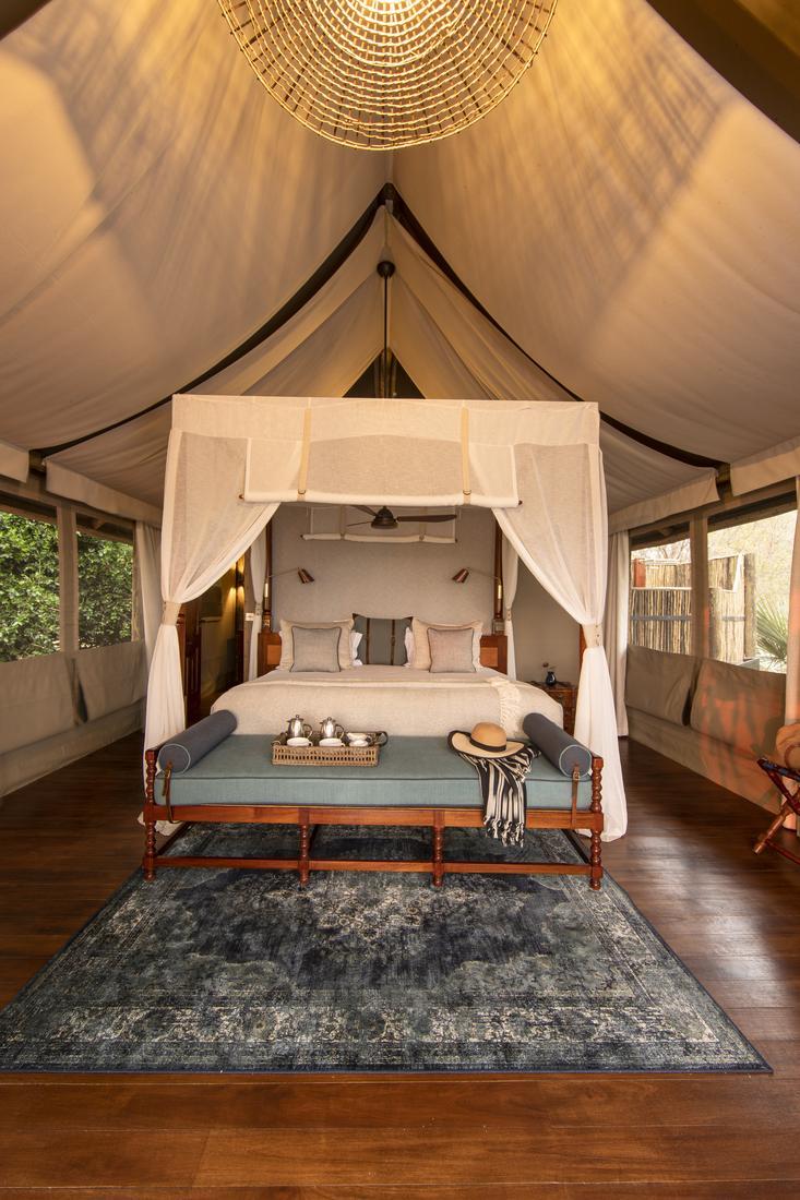 A bedroom in one of the tents at Shinde Camp, featuring a canopy bed.