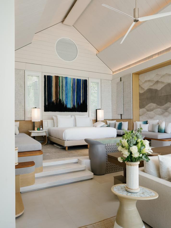 The bedroom of a beach villa at Cheval Blanc Seychelles, featuring a neutral palette and airy, vaulted ceilings.