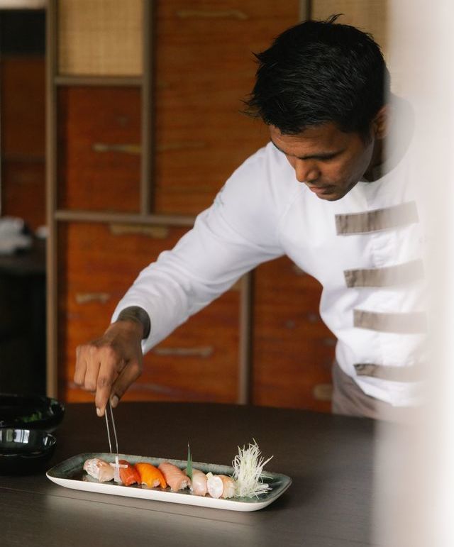 A chef from Mizumi Restaurant at Cheval Blanc Seychelles preparing a plate of sushi.