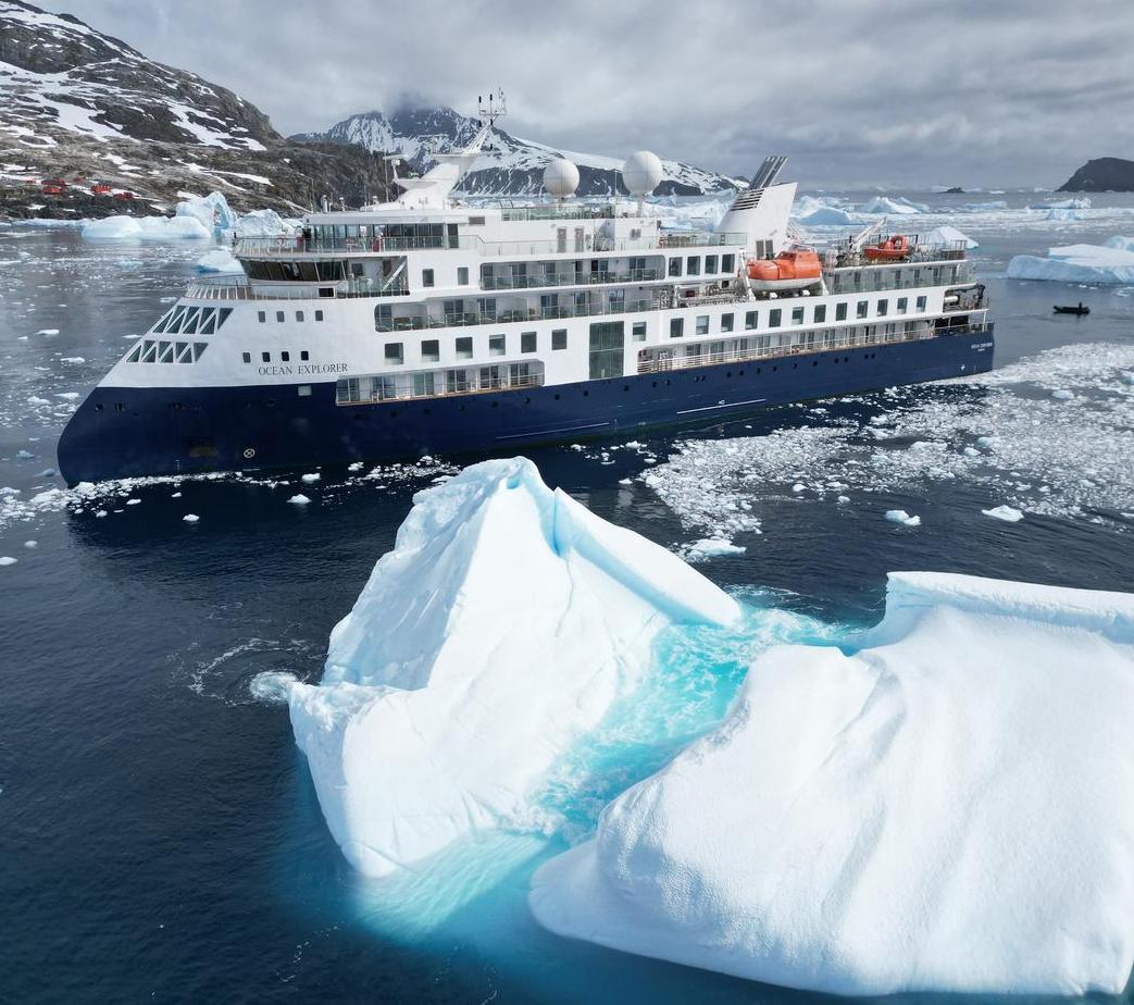 A view of the Ocean Explorer with an iceberg in the foreground.