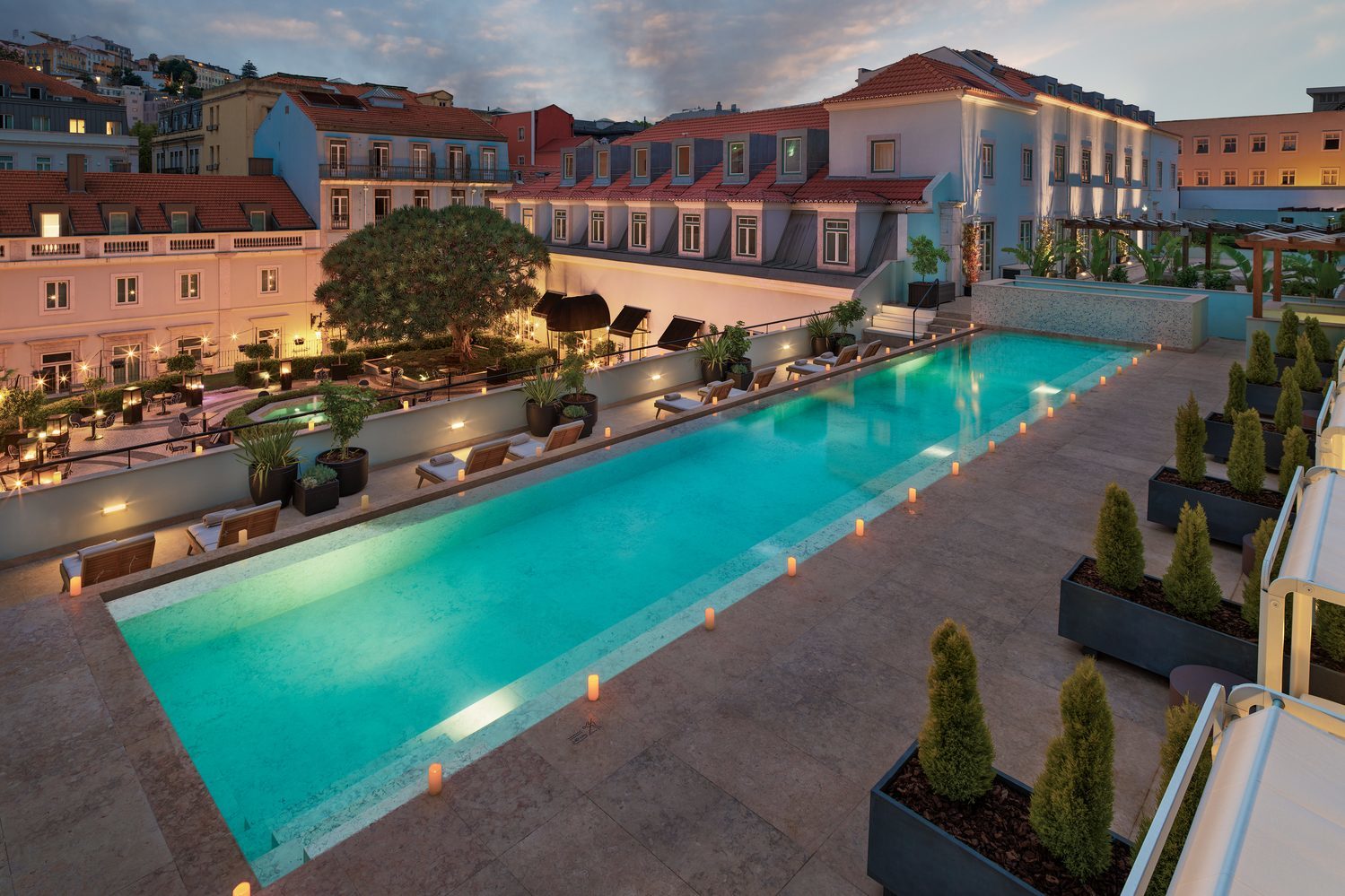 A view of the outdoor pool at dusk at The One Palacio da Anunciada