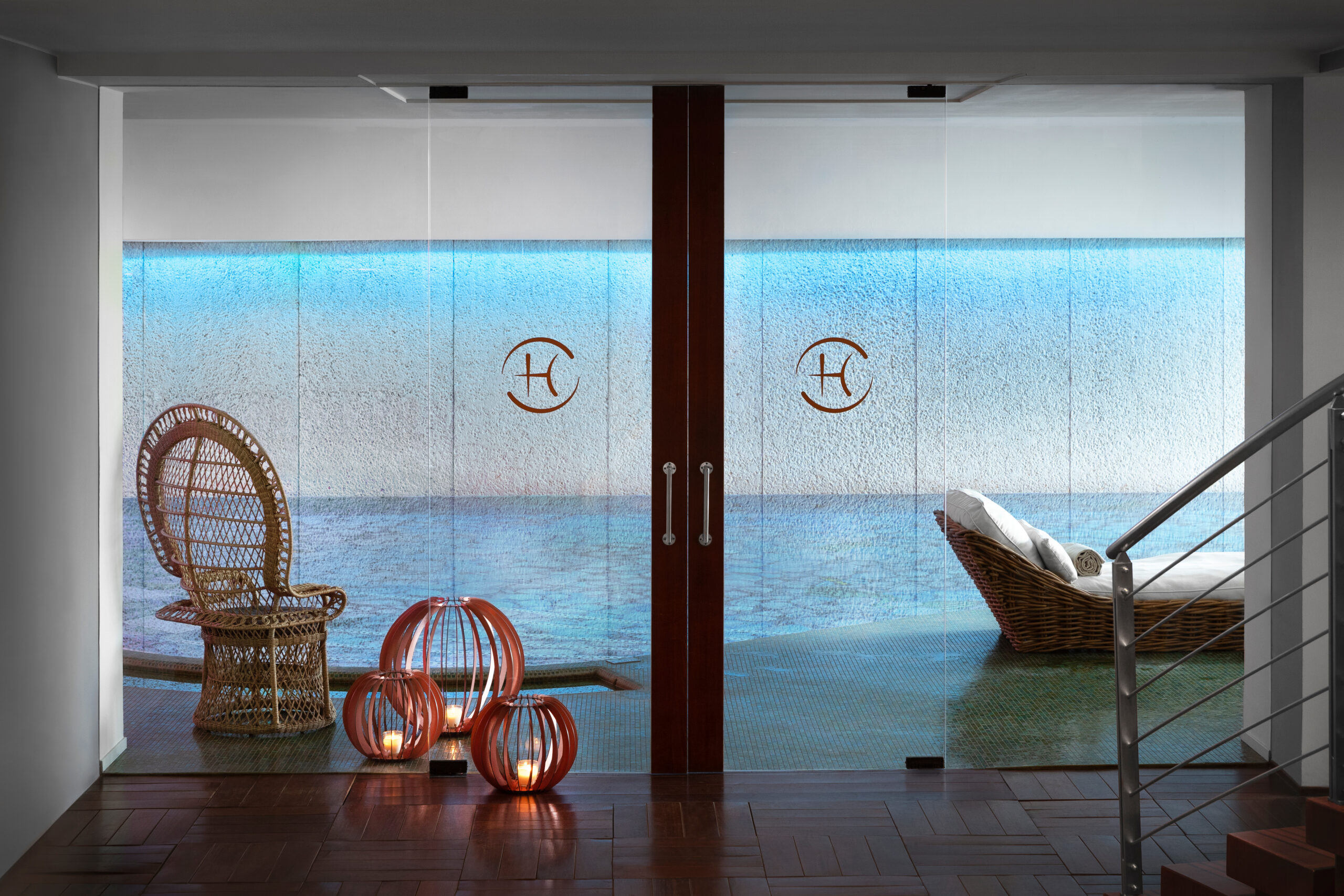 Frosted glass doors indicating the entryway to a spa, with candles and a wicker chair.