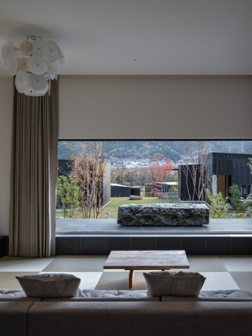 Modern sitting room with a large picture window overlooking a grassy outdoor area