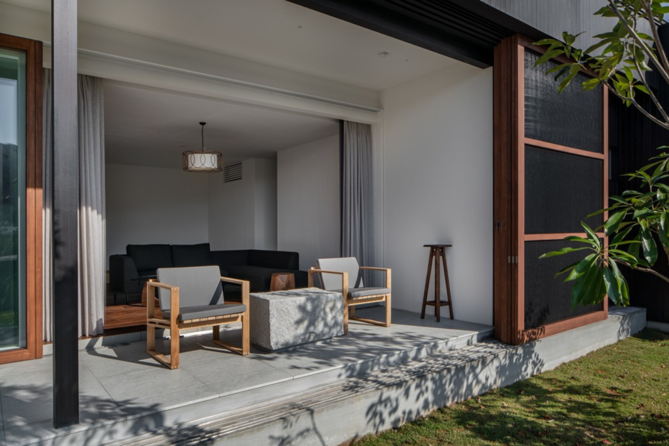 Covered terrace at ground level with two chairs and a square table
