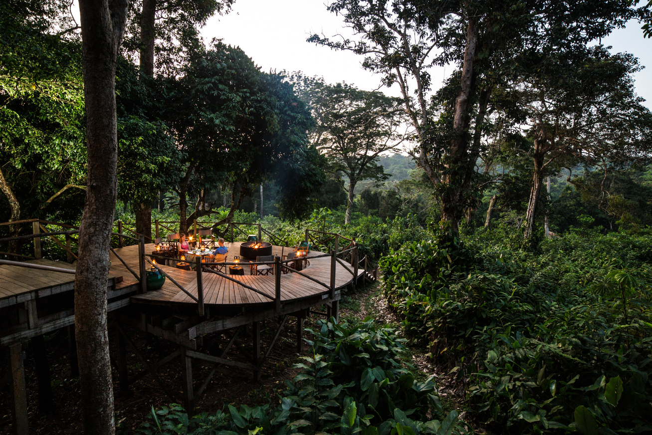 Round raised wooden deck with a table for two, bonfire and views of the forest