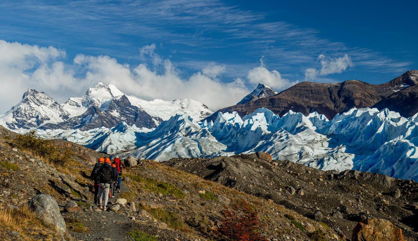 A group of people walking towards the Perito Moreno Glacier in Patagonia.
