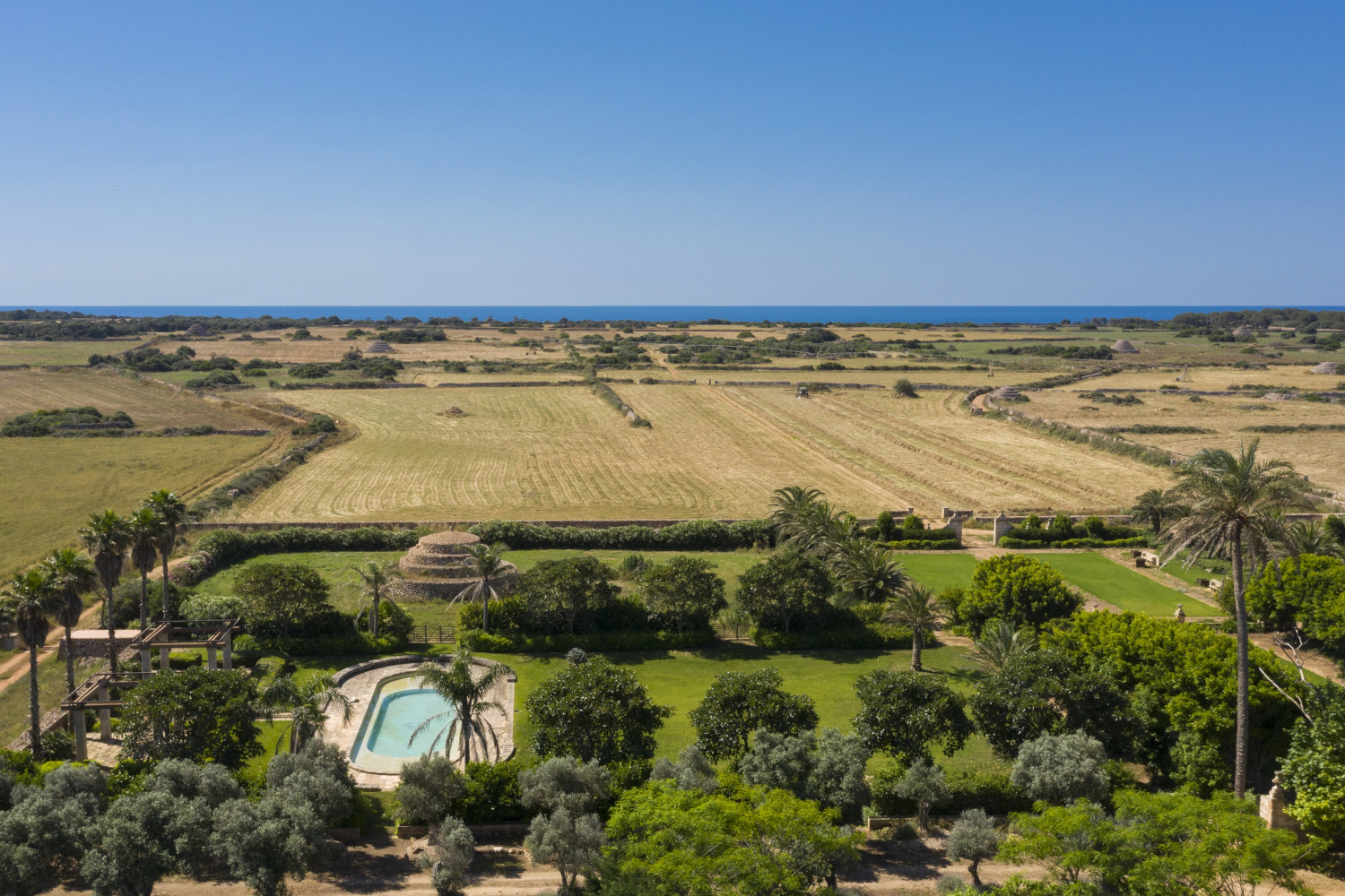 Aerial view of Son Vell in Balearic Islands Spain featuring a swimming pool, green gardens, and rural landscape.