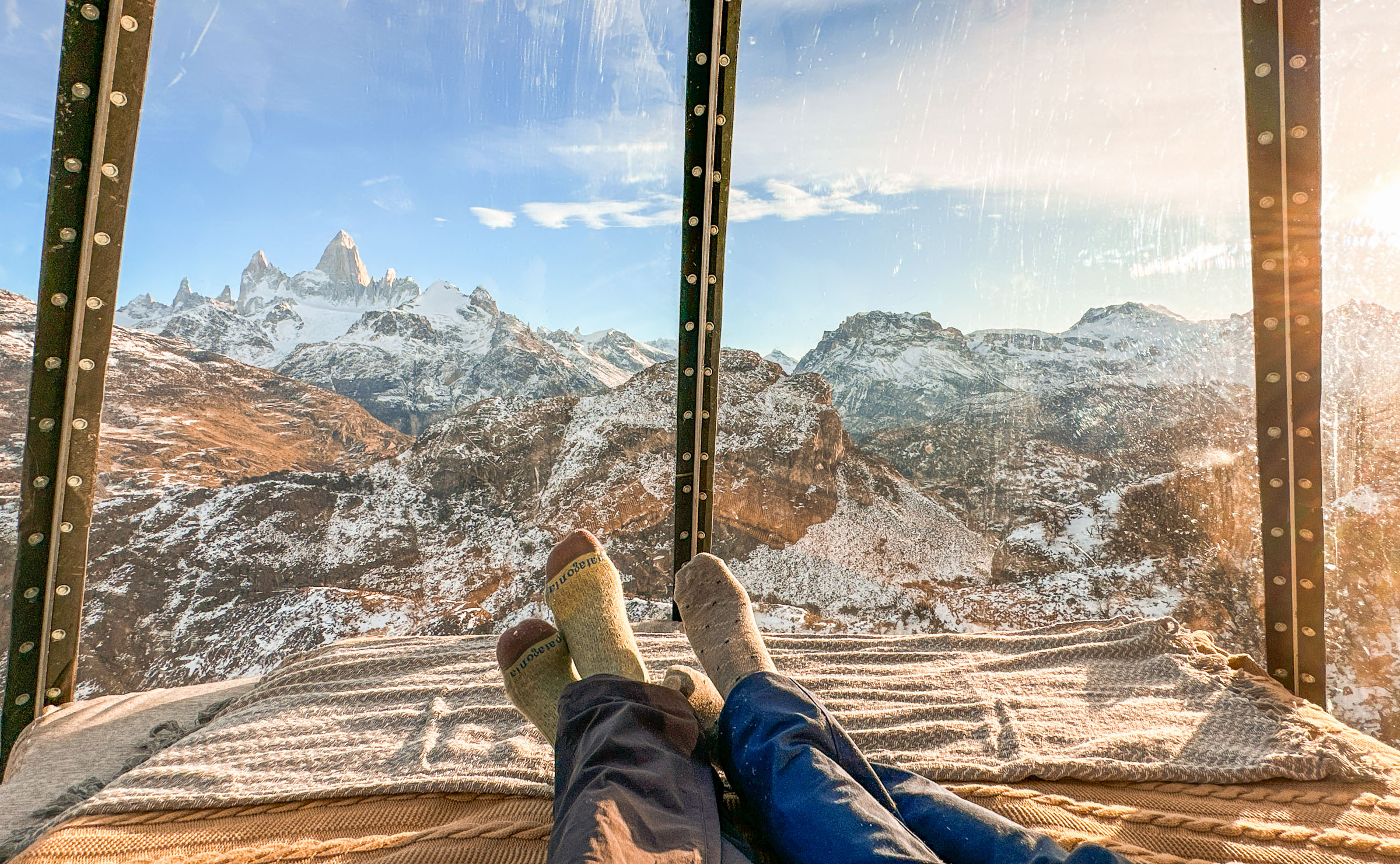 View of the feet of a couple relaxing in a viewing pod overlooking Mount Fitz Roy