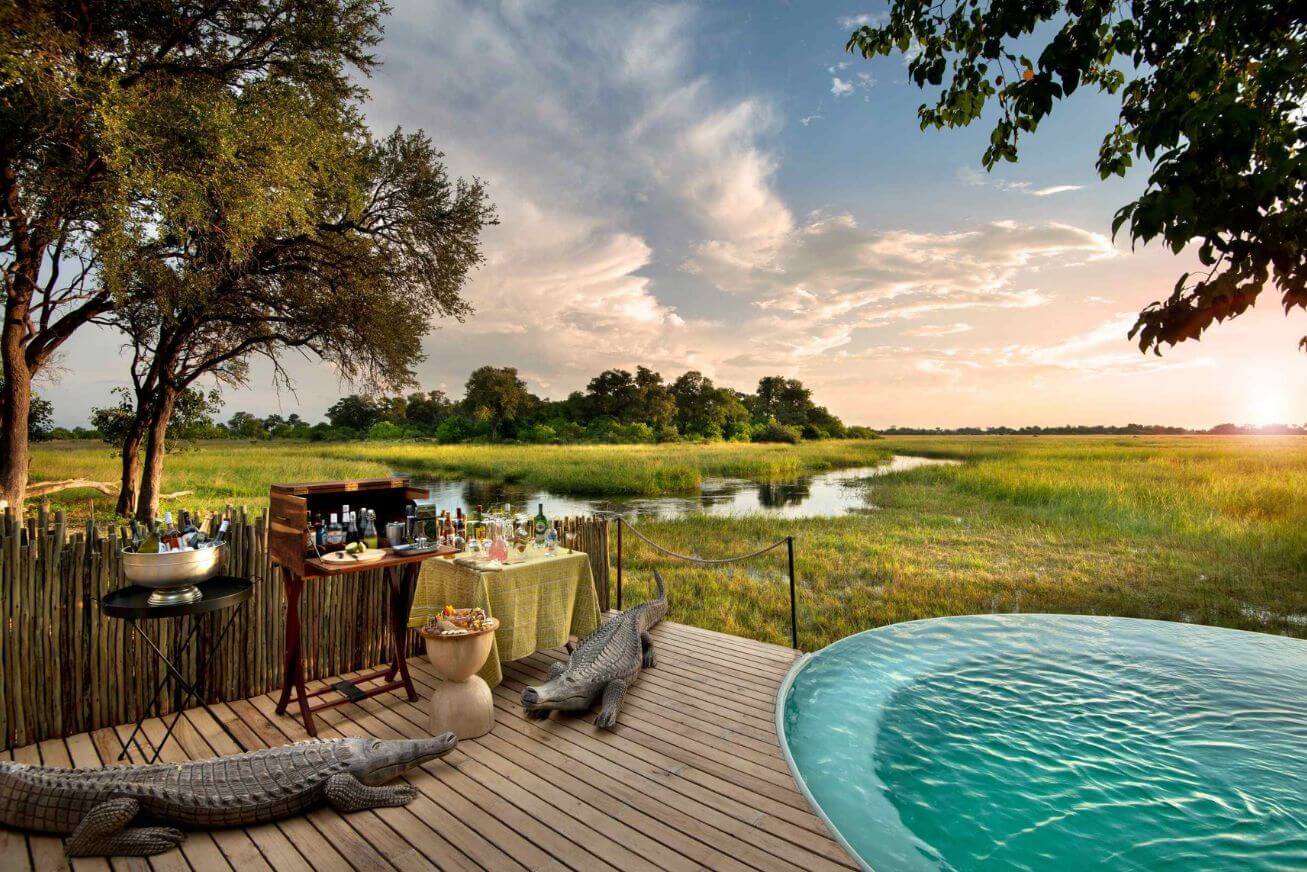 Wooden deck with drinks station and swimming pool beside a river