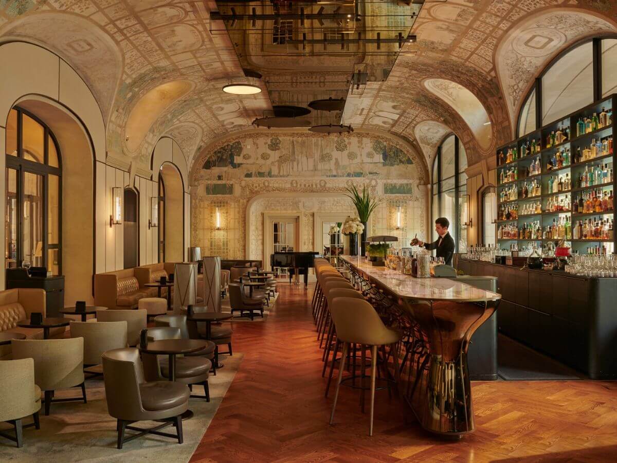 An elegant hotel bar with a curved and frescoed ceiling