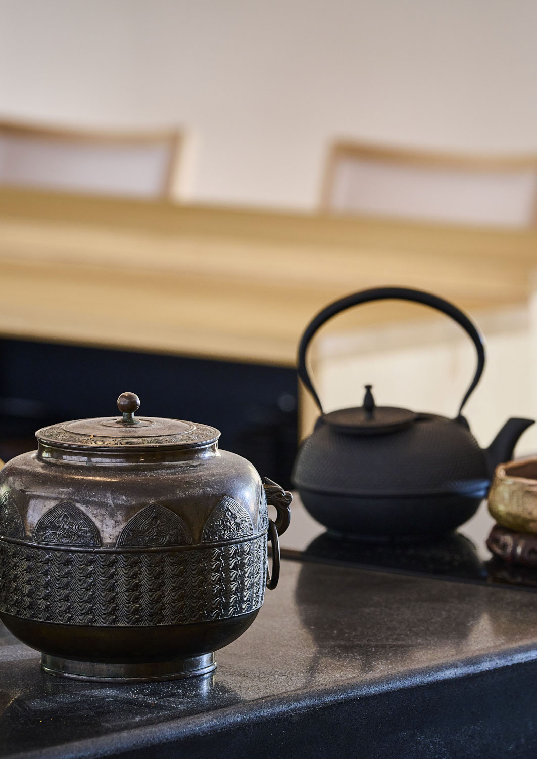 Close-up shot of a ceramic pot and teapot with decorative carvings.