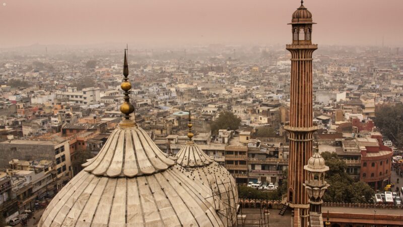 Domes and a minaret of Jama Masjid overlook Old Delhi's bustling rooftops.