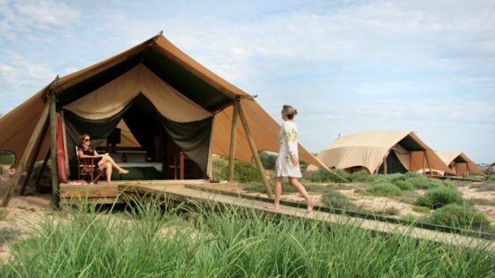 Woman walking into tent, Sal Salis, North West Australia