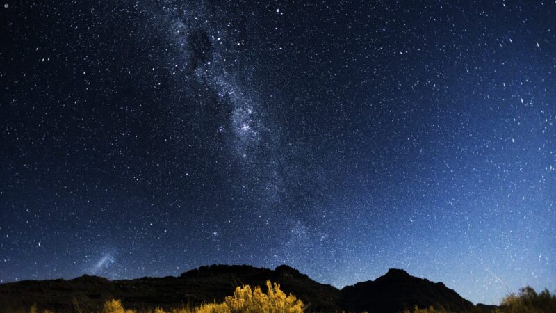 A starry night sky featuring the Milky Way over dark mountain peaks on luxury Western Cape vacations.
