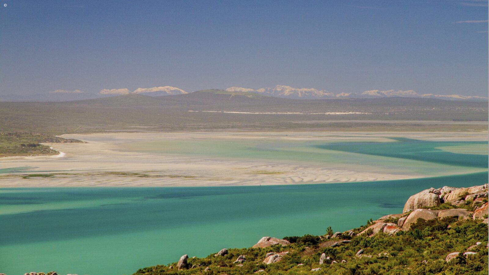 High angle view of a bright turquoise lagoon and sandy shores, perfect for luxury Western Cape holidays.