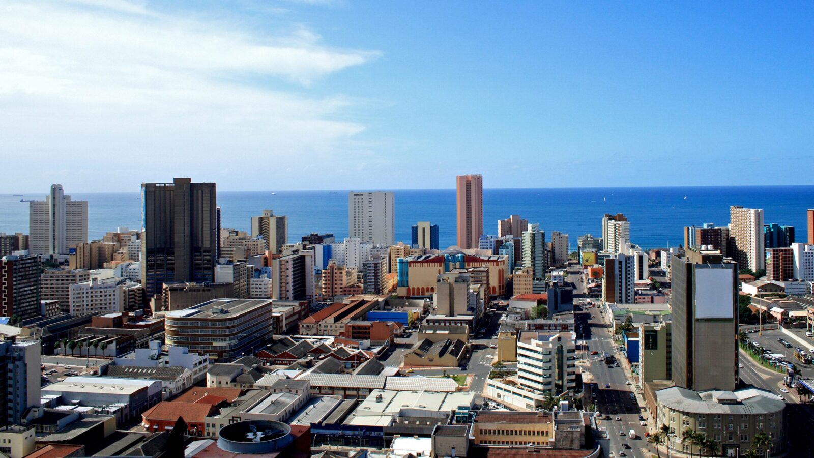 High-angle view of city buildings and the ocean horizon during luxury Durban trips