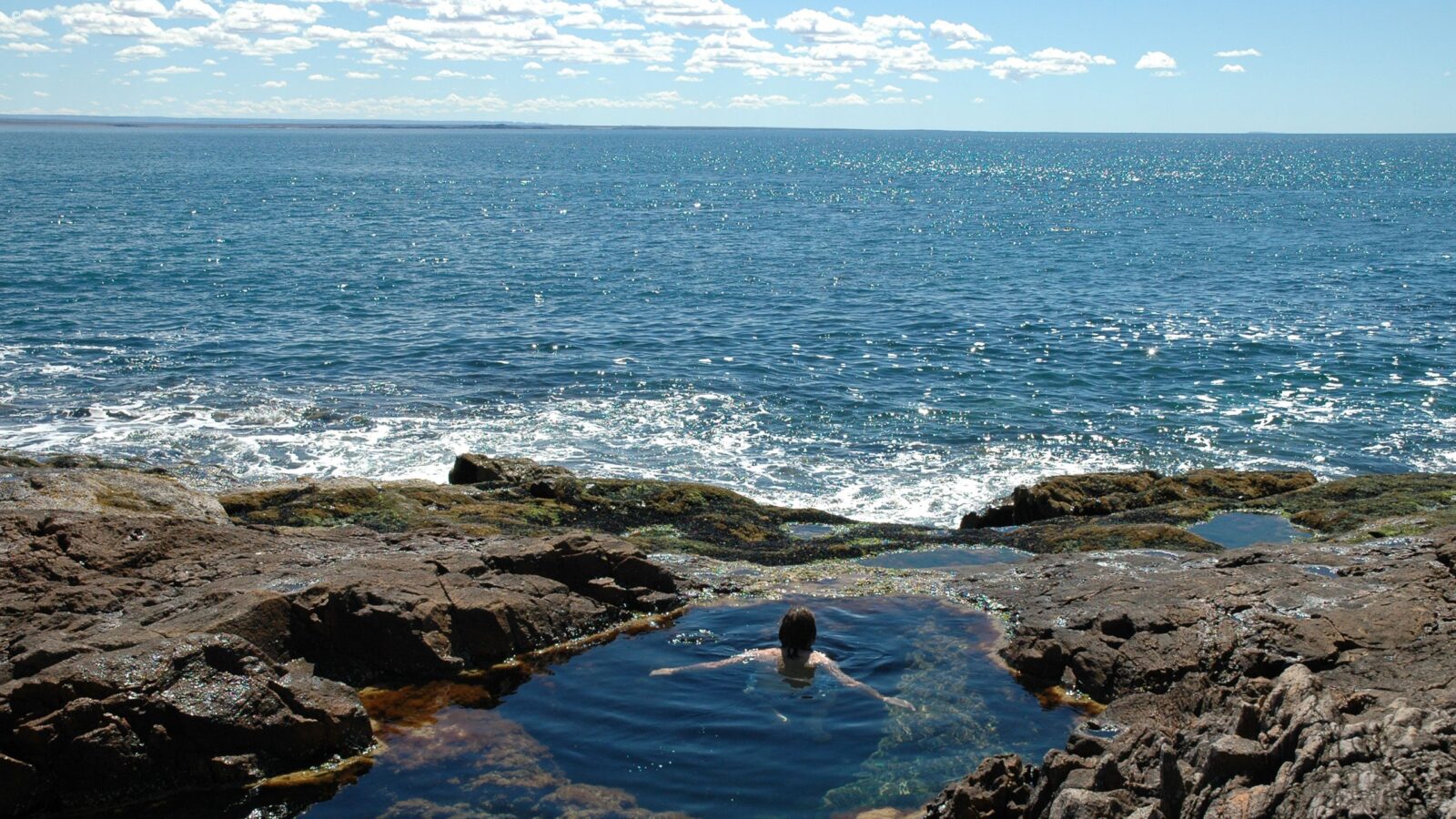 Woman bathing in pool, Bahia Bustamante, Argentina