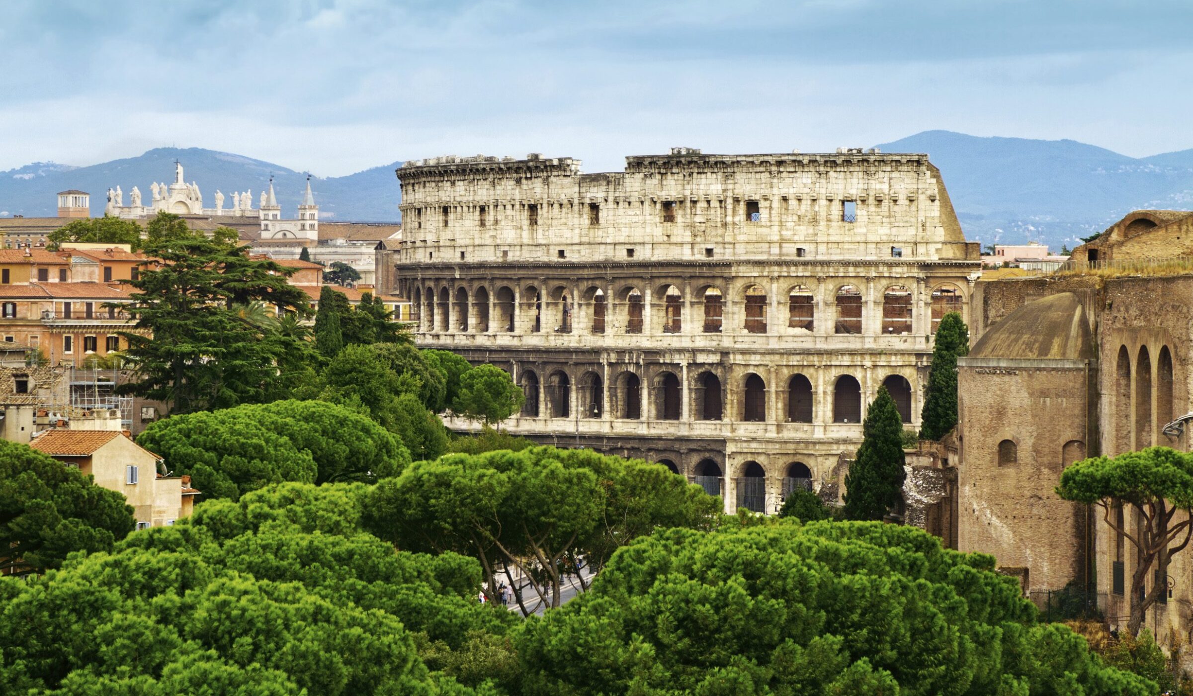 Luxury Italy Tours - Rome Colosseum amongst lush green trees