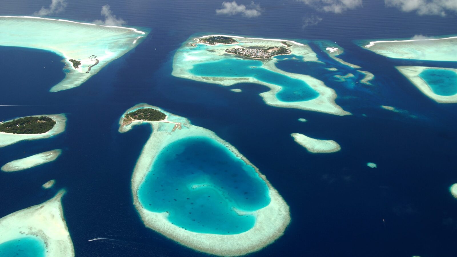 Aerial view of small, sandy islets in deep blue sea