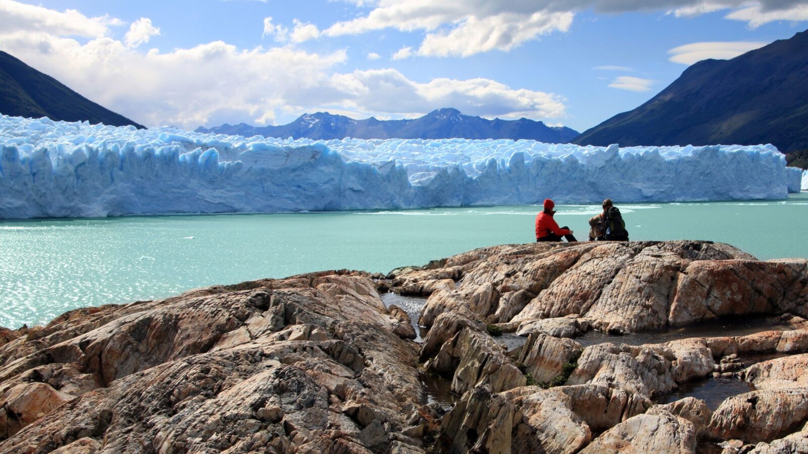 Travelers overlooking the massive Perito Moreno Glacier on luxury Latin America honeymoon trips.