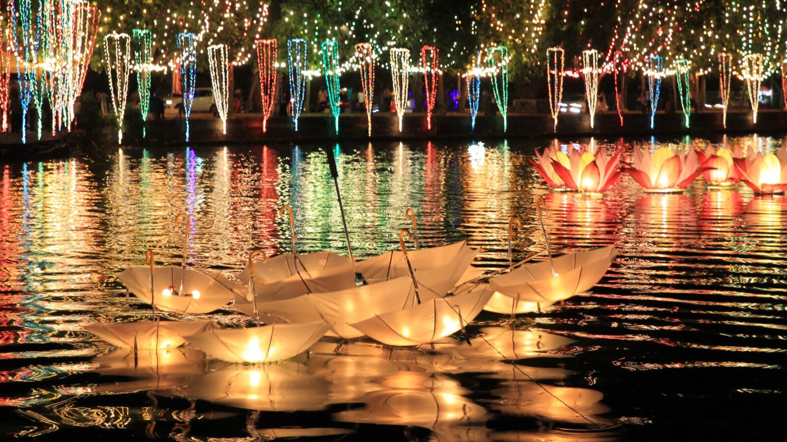 Floating umbrella lanterns and lotus lights on a lake during luxury Sri Lanka holidays.