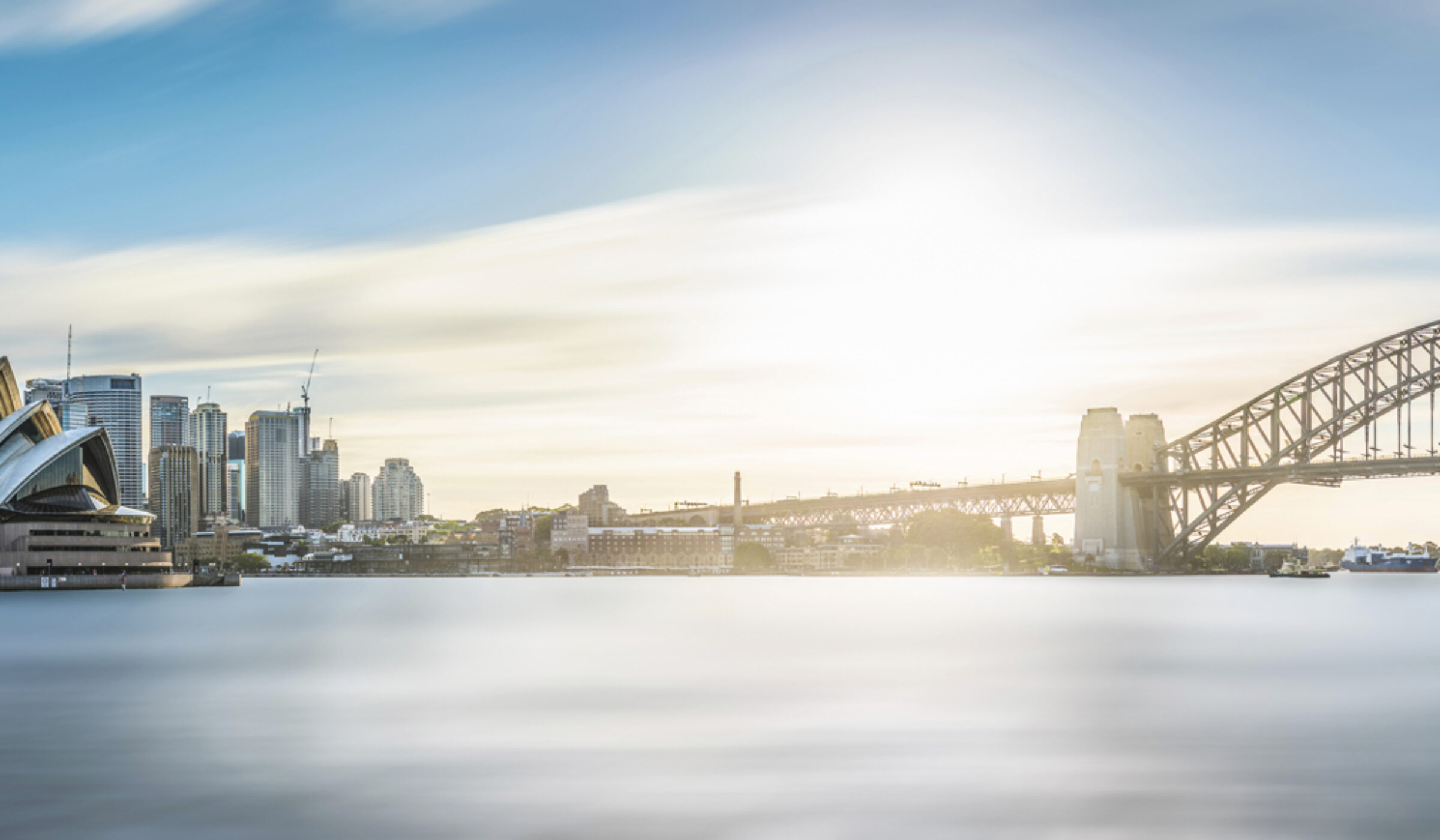 A wide panorama of the Sydney Opera House and Harbour Bridge, ideal for luxury Australasia holidays.