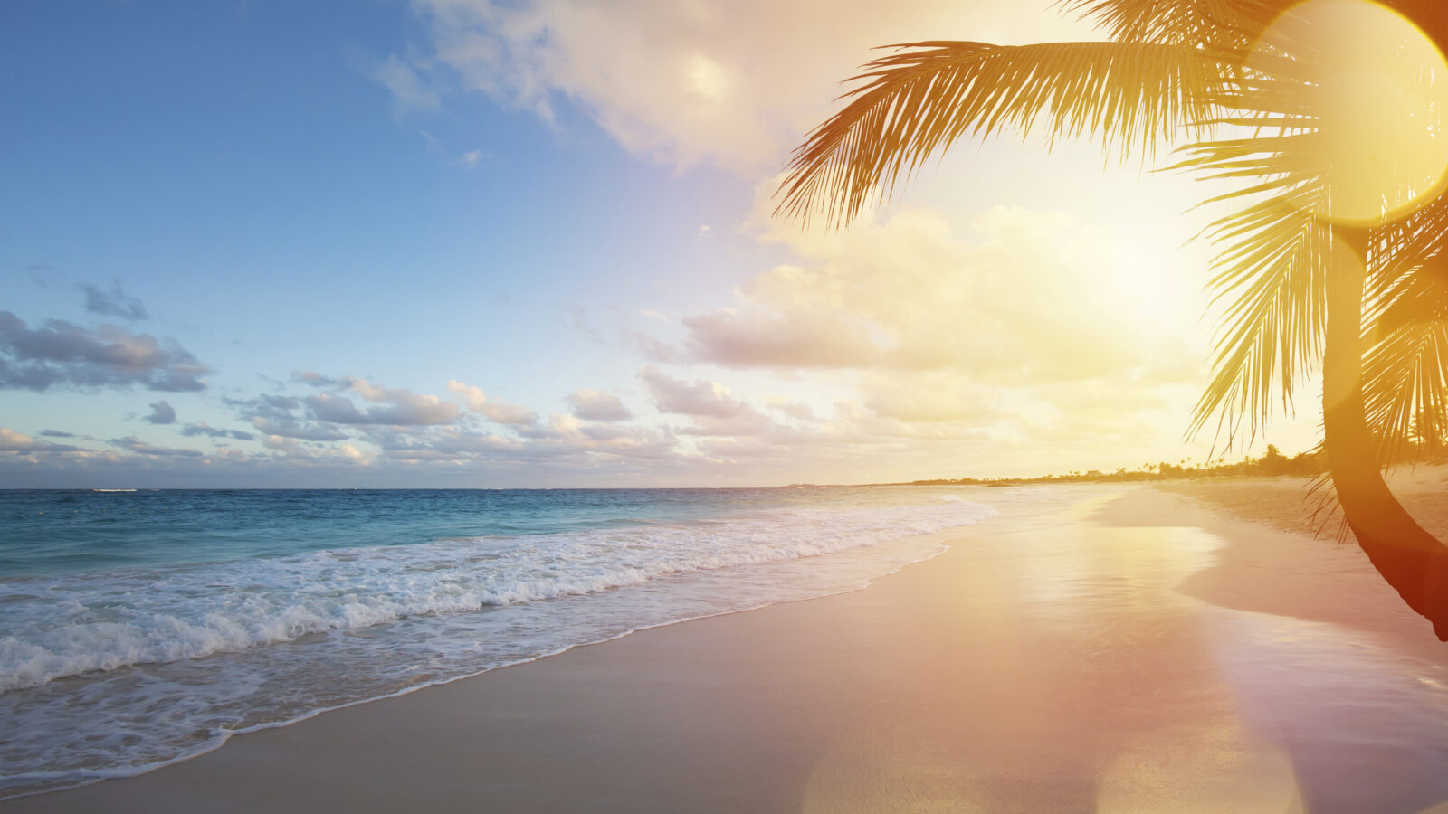 A golden sunset over a tropical white sand beach during luxury Bali trips.