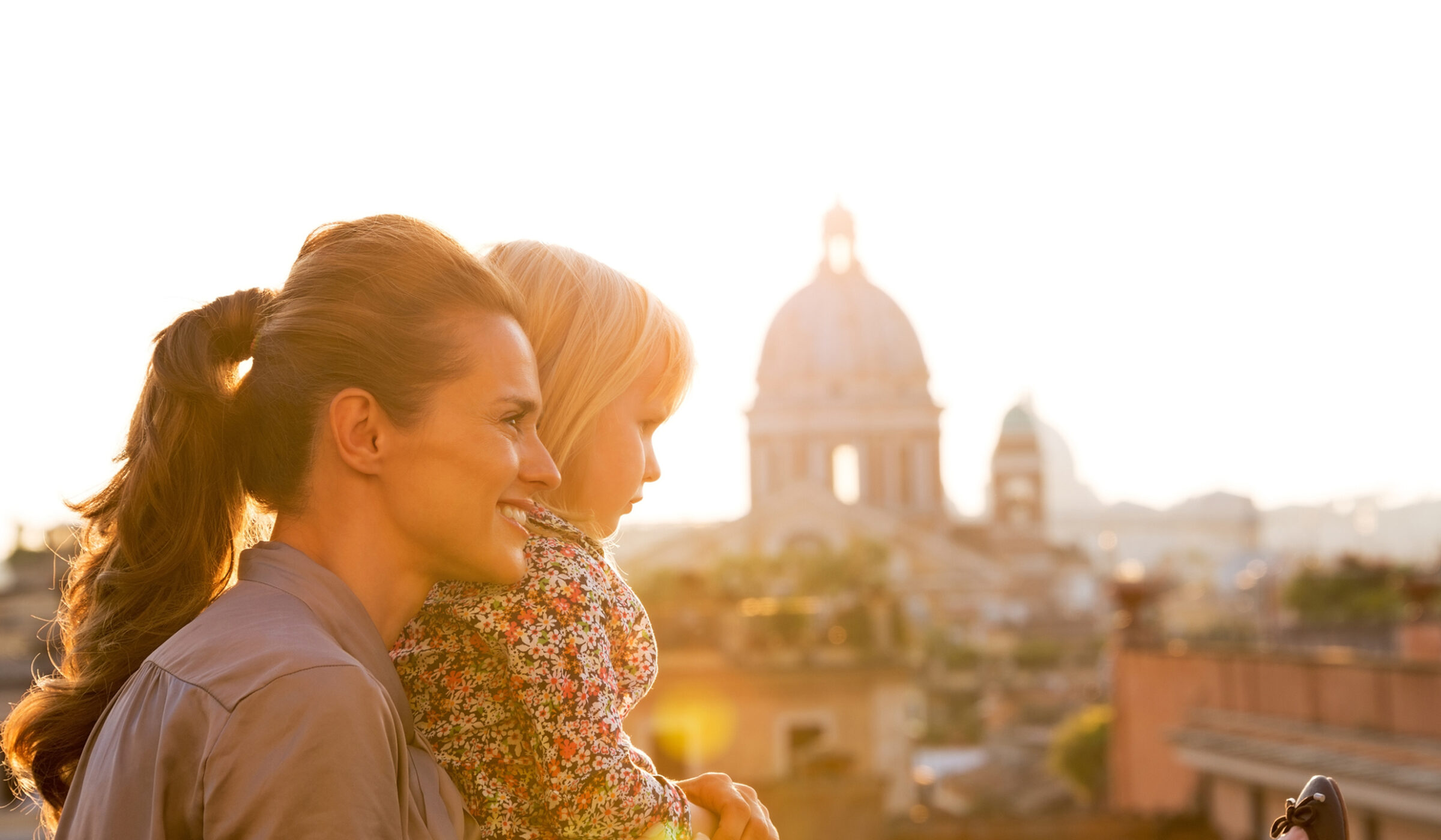 A mother and daughter viewing a cathedral dome at sunset during luxury Europe family tours.