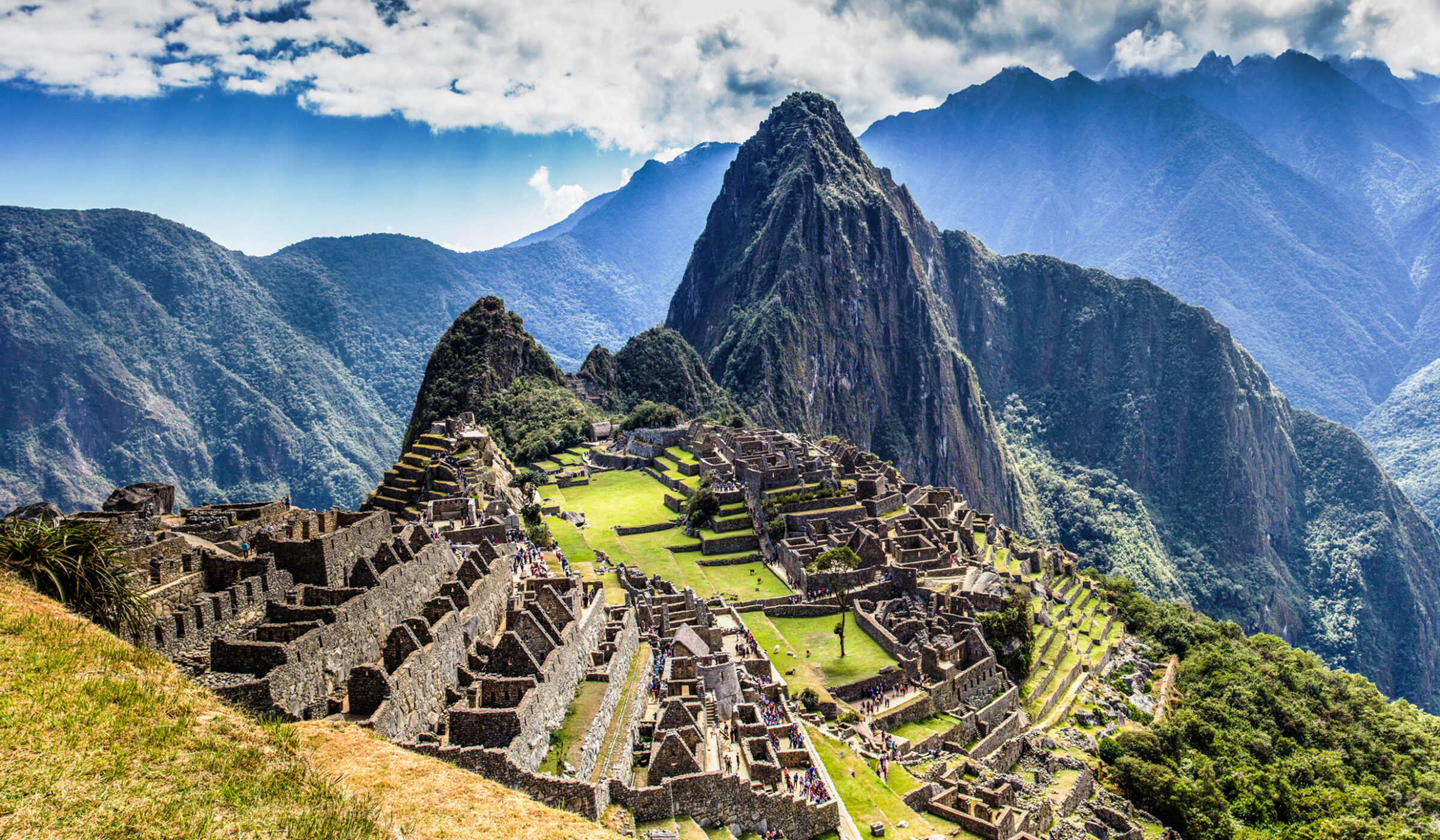 epic expeditions - The ruins of ancient citadel Machu Picchu in the Peruvian mountains on a bright and cloudy day, luxury Machu Picchu tour.