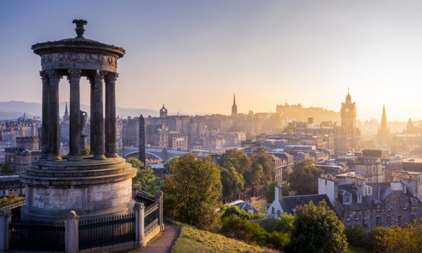 The Dugald Stewart Monument on Calton Hill overlooking the Edinburgh city skyline.