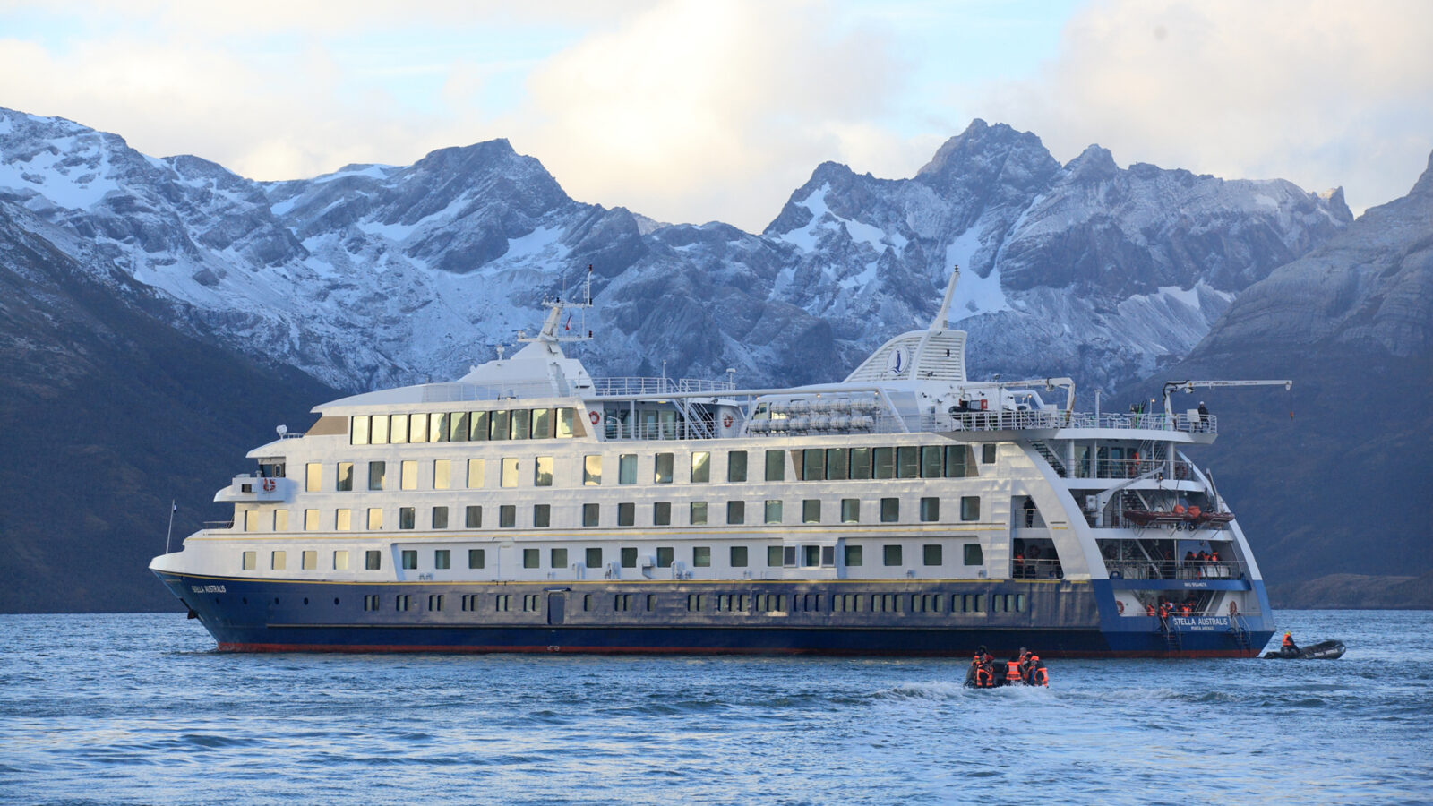 Expedition ship cruising near snowy mountains around Cape Horn
