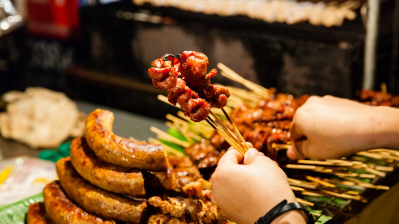 CHIANG MAI, THAILAND: Man buys skewered grilled pork