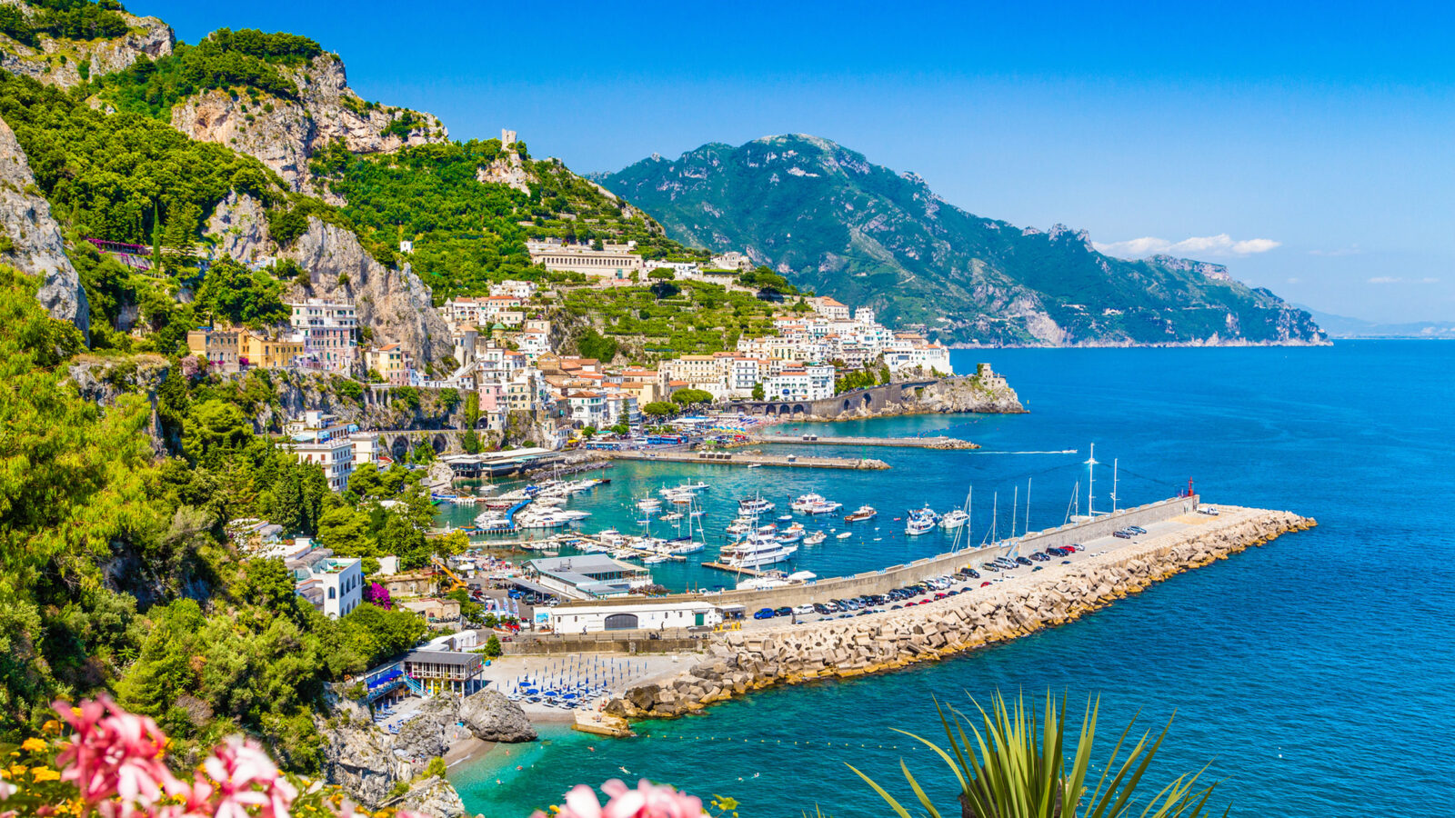 Harbor with many boats and white cliffside buildings during luxury Amalfi Coast tours.